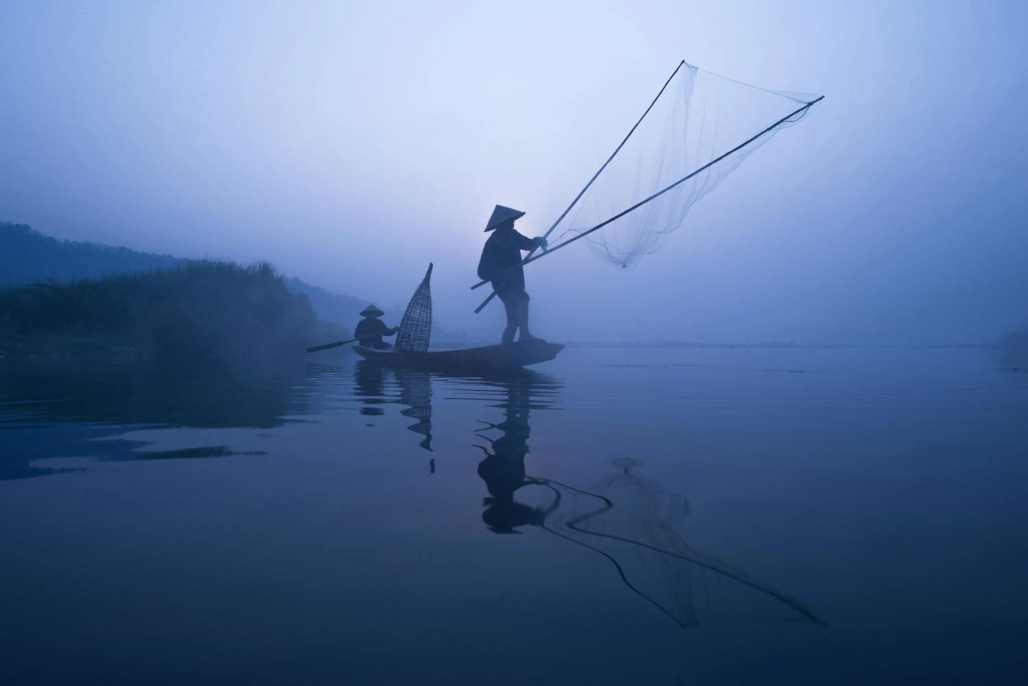 shutterstock 414418321 Fiskare seglar ut i båt med nät